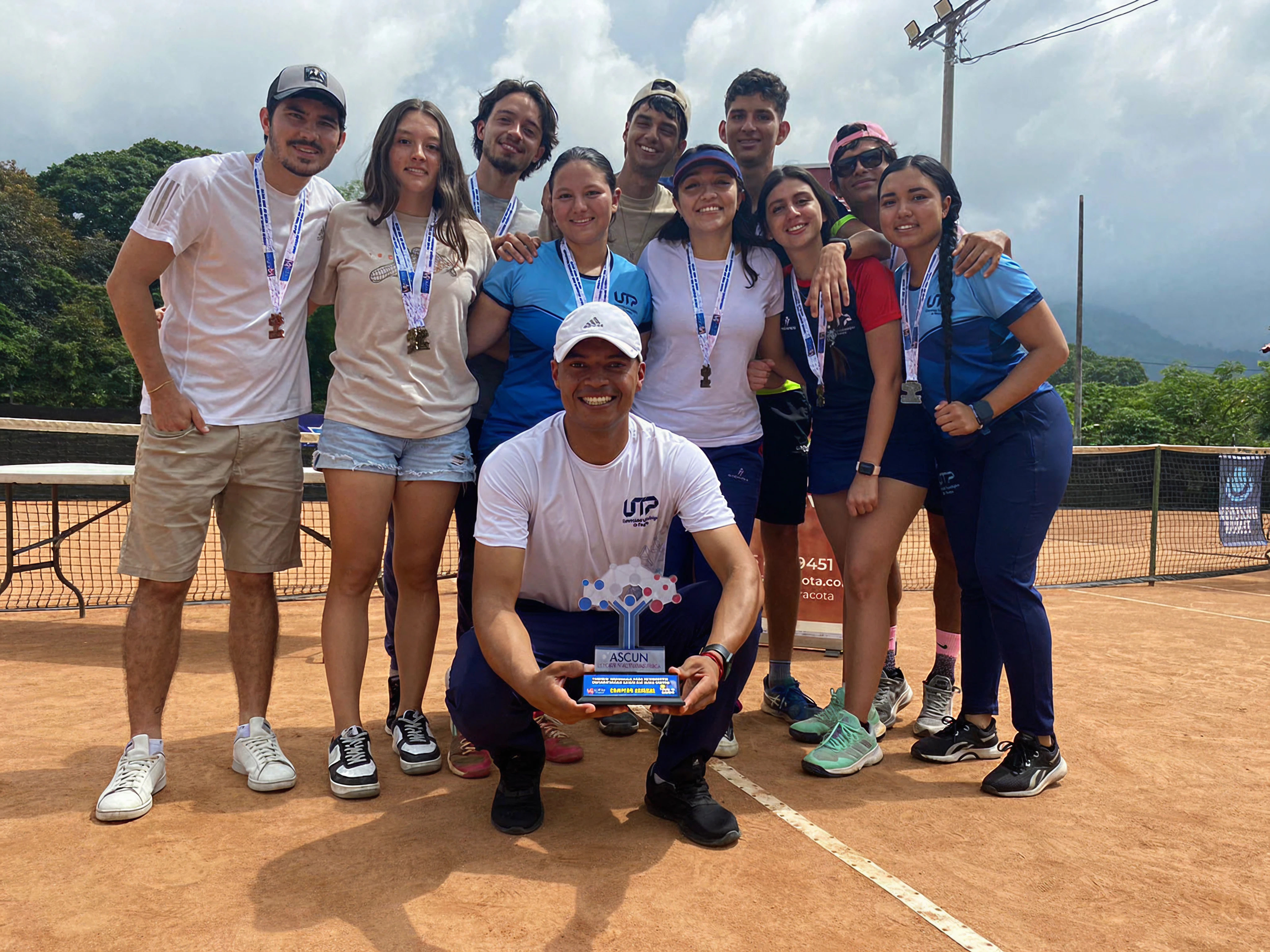 Dave Alzate and university tennis team holding the zone championship trophy — now offering tennis lessons in Regina, SK