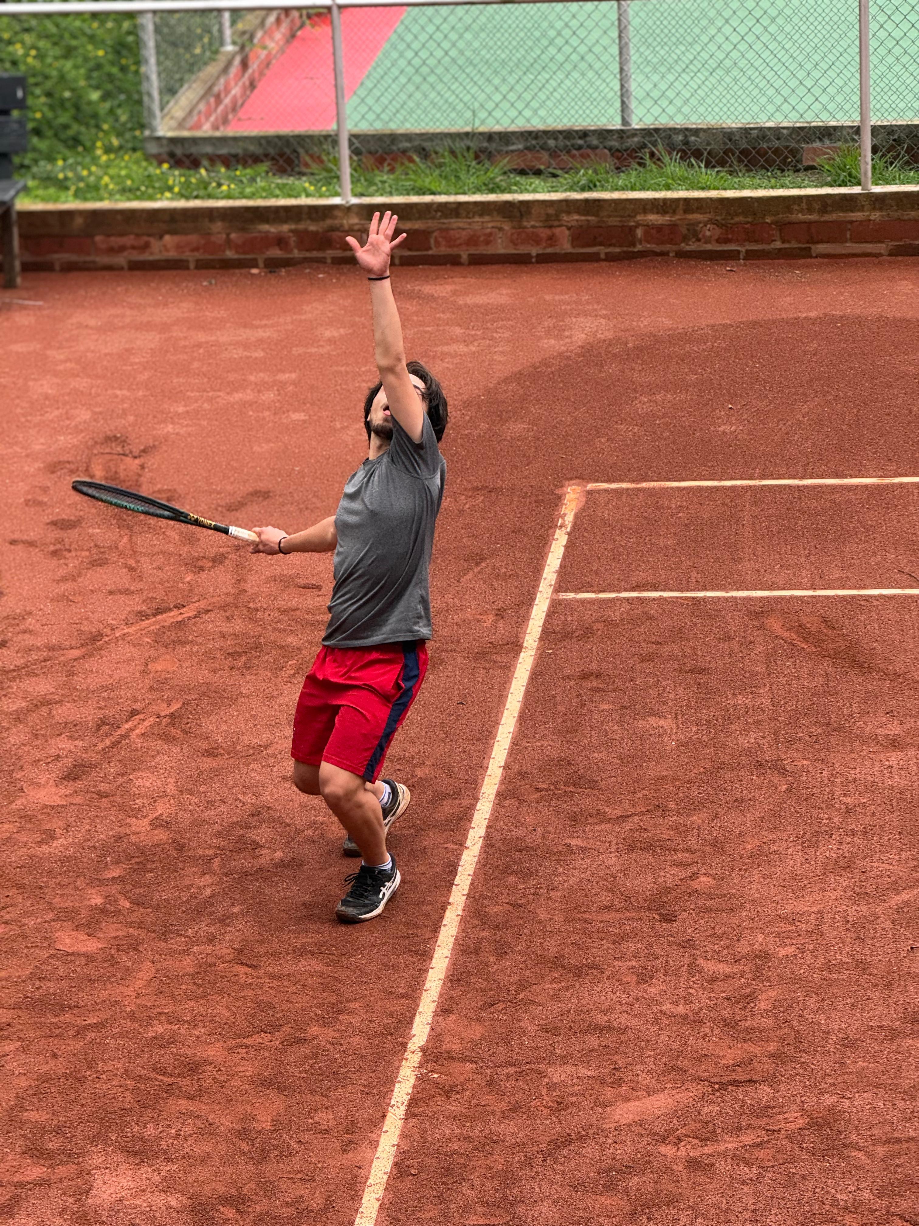 Dave Alzate, tennis instructor in Regina, Saskatchewan, reaching up to execute a serve